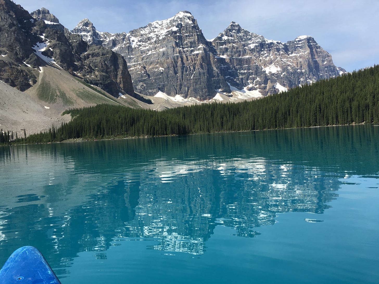 Family canoeing on Lake Louise in Canadian Rockies, accessible multi-generational activity with mountain views