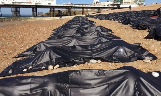 This may contain: there are many black tarps lined up on the beach