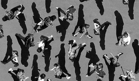 This may contain: black and white photograph of people laying on the ground with their shadows cast by them