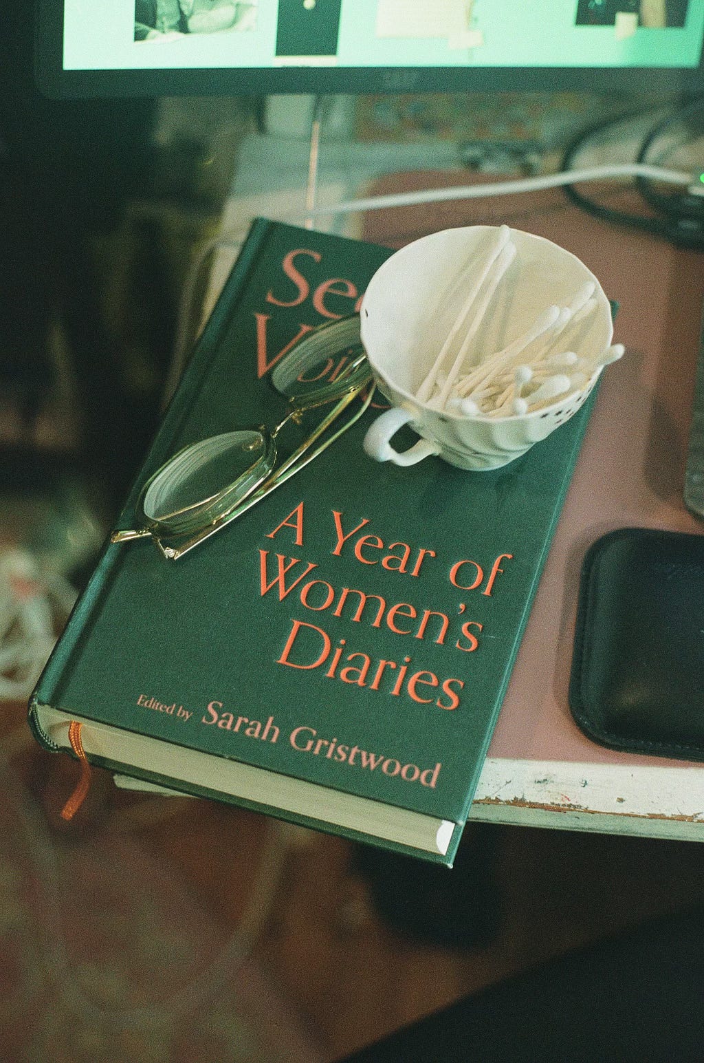 A teacup on a book with a pair of glasses A teacup on a book with a pair of glasses