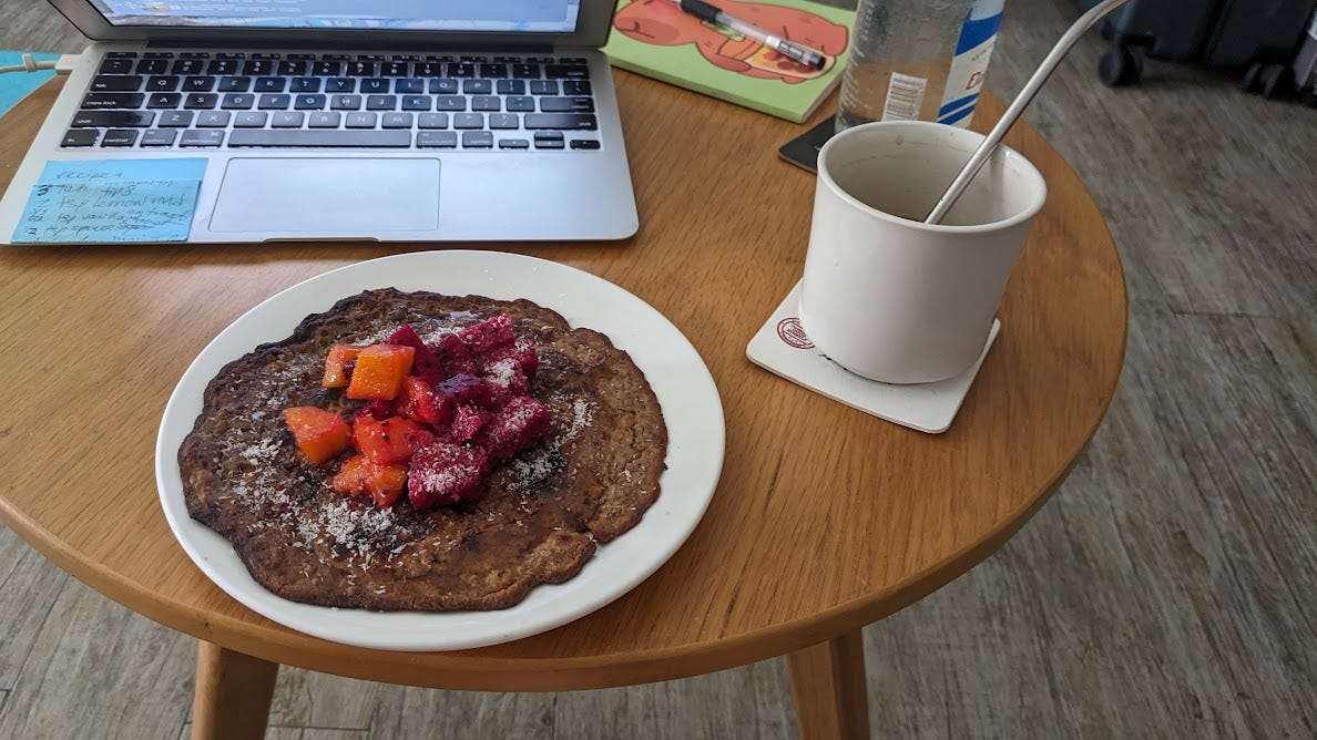 pancake on coffee table with coffee mug and laptop