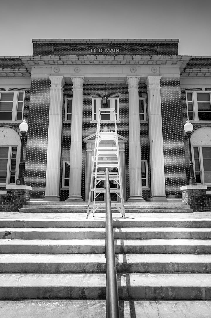 "Pawsitively" where you need to be sign with pom poms and flag, main building with ladder used by theatre students over the summer