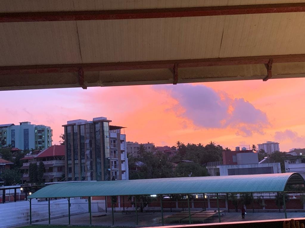 A view of buildings and a sunset from a roof