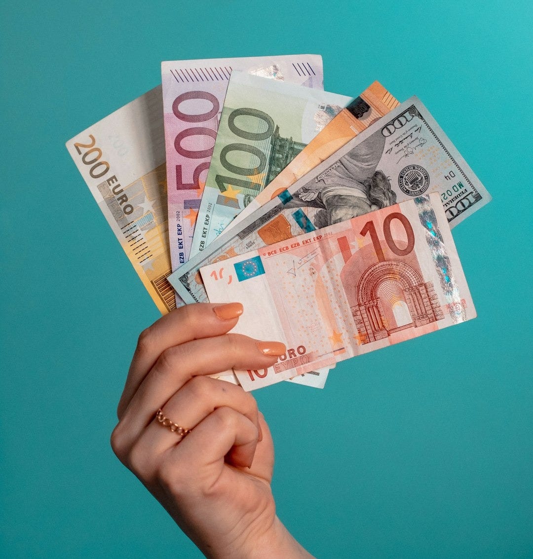 person holding fan of 100 us dollar bill