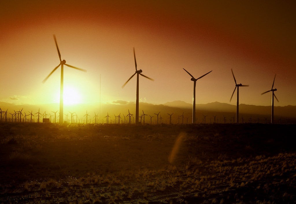 A vivid sunset silhouettes scores of wind turbines in California A vivid sunset silhouettes scores of wind turbines in California