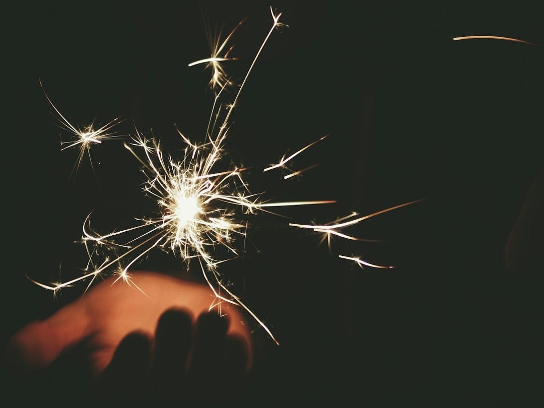 person hand bellow sparkling light
