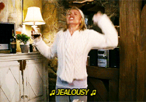 Camerone Diaz in the Holiday singing "Jealousy" from Mr. Brightside while wearing a white sweater and holding a glass of wine