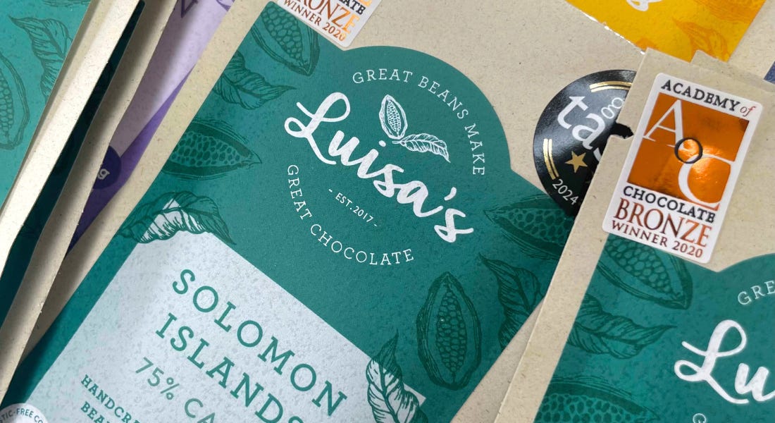 A close-up of Luisa's Vegan Chocolates' bars with blue and grey packaging A close-up of Luisa's Vegan Chocolates' bars with blue and grey packaging