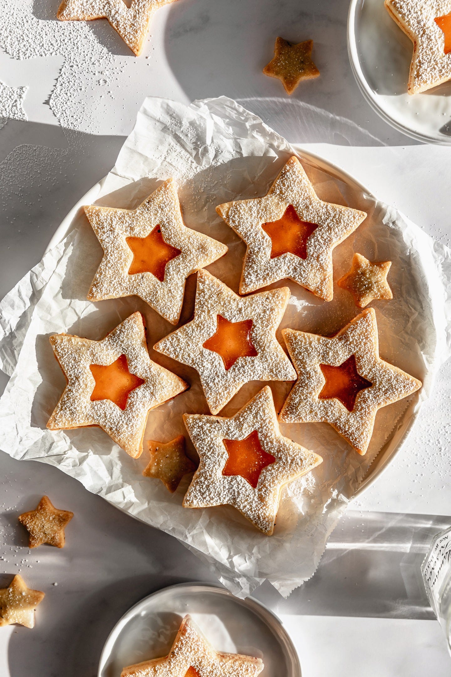 Vegan apricot rosemary linzer stars on parchment lined plate Vegan apricot rosemary linzer stars on parchment lined plate