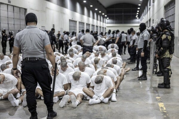 In this photo provided by El Salvador's presidential press office, a prison guard transfers deportees from the U.S., alleged to be Venezuelan gang members, to the Terrorism Confinement Center in Tecoluca, El Salvador, Sunday, March 16, 2025. (El Salvador presidential press office via AP) In this photo provided by El Salvador's presidential press office, a prison guard transfers deportees from the U.S., alleged to be Venezuelan gang members, to the Terrorism Confinement Center in Tecoluca, El Salvador, Sunday, March 16, 2025. (El Salvador presidential press office via AP)
