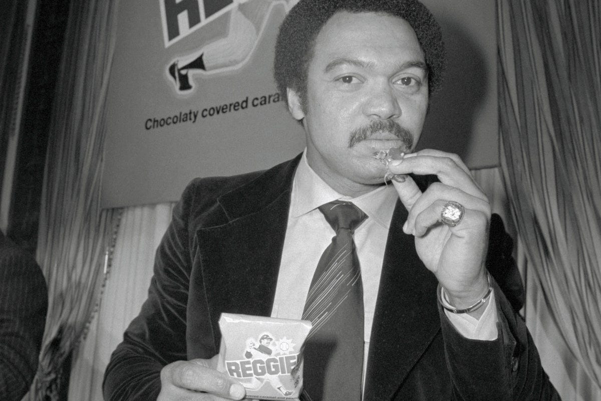 Reggie Jackson holds a Reggie! Bar at a New York rollout event.