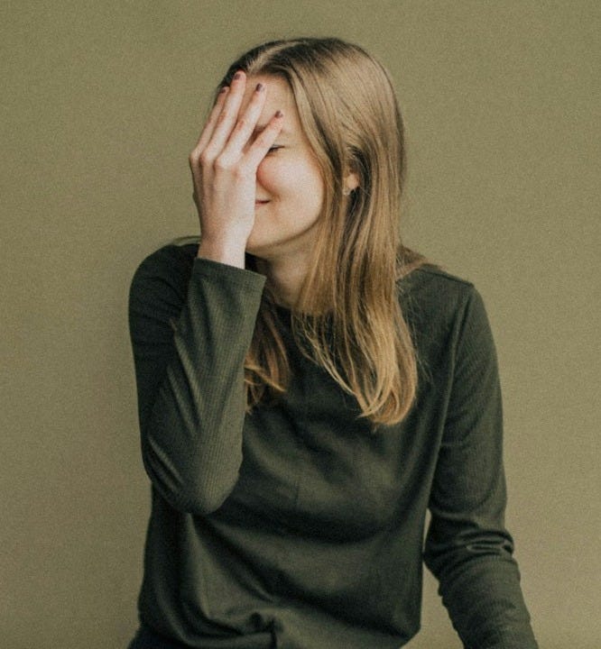 woman in black long sleeve shirt and blue denim jeans sitting on brown wooden chair