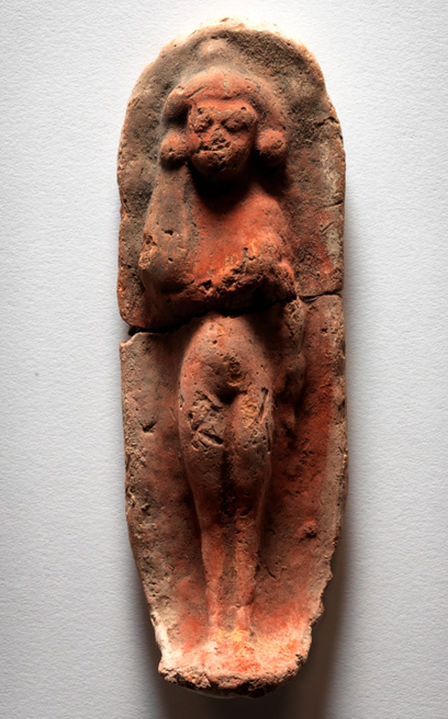 Figurine of a woman laying on a bed.