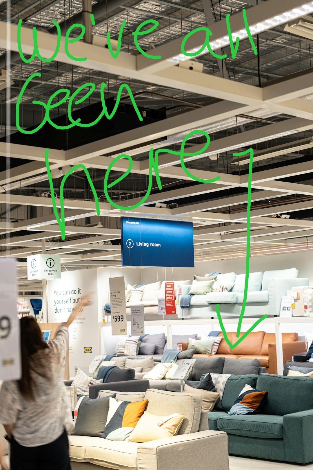 a woman holding a sign in a furniture store a woman holding a sign in a furniture store