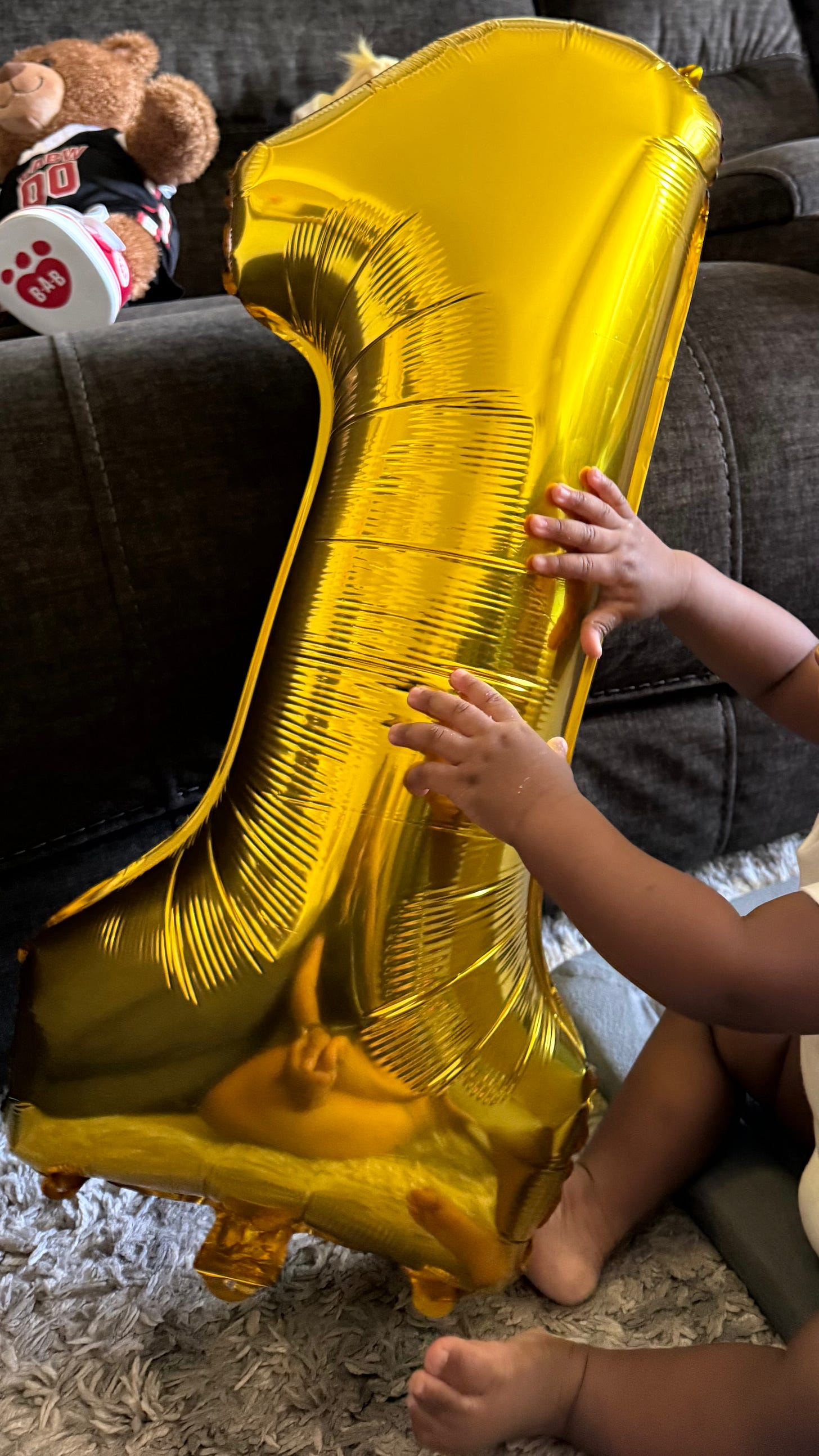 baby hands touching gold numbered one balloon baby hands touching gold numbered one balloon