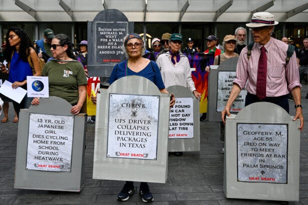 Protesters hold gravestones for heat deaths during Elders Week Protesters hold gravestones for heat deaths during Elders Week