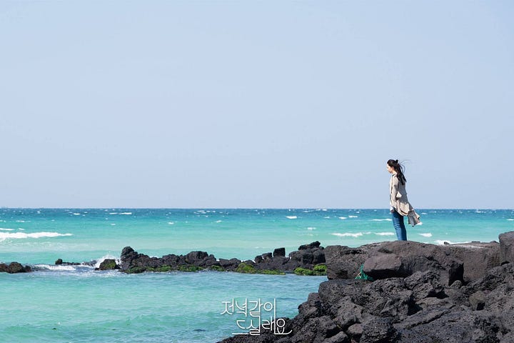 A man and a woman looking melancholy on the beach in Jeju Island