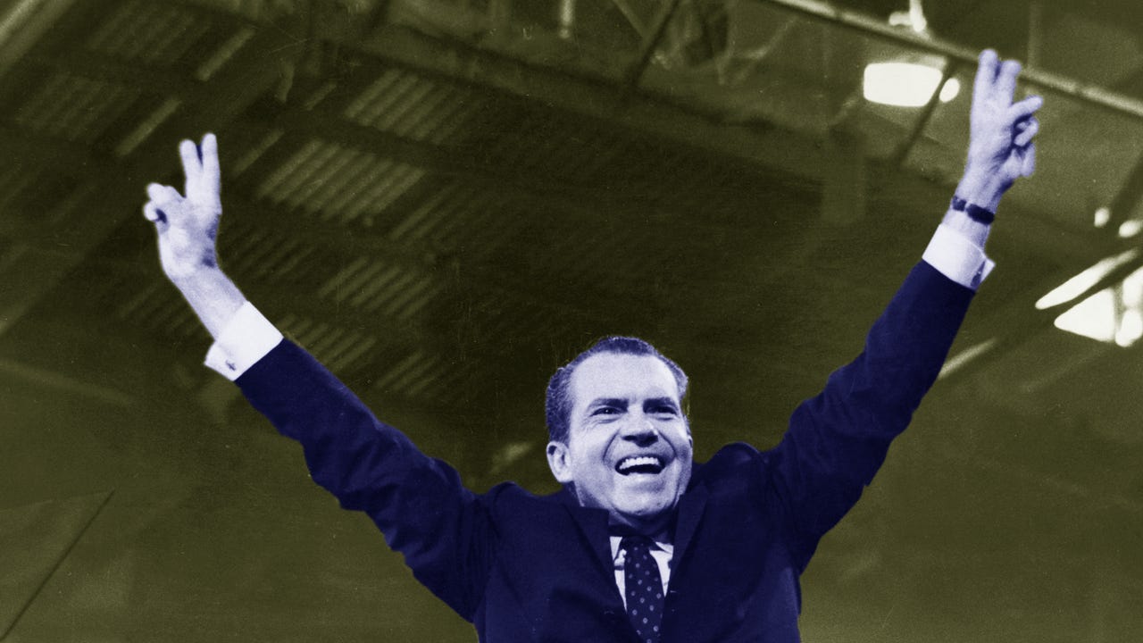 President Richard Nixon doing the V for victory pose with his arms.