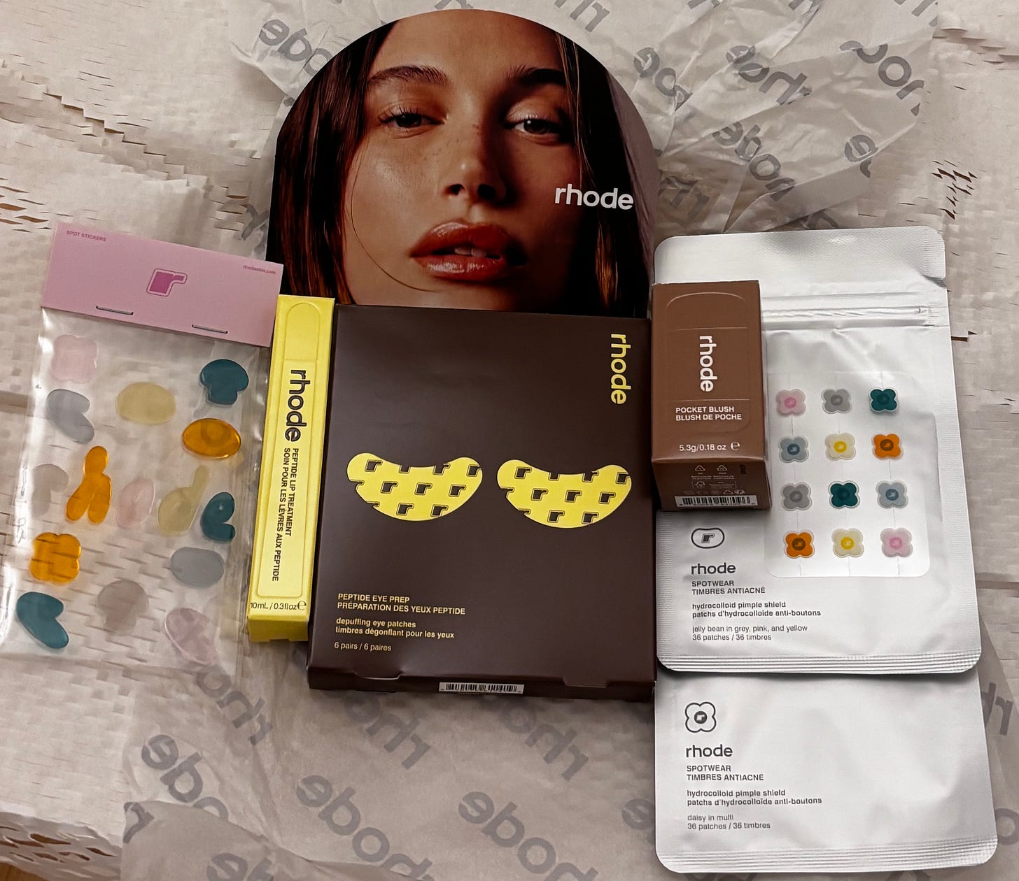 The complete Rhode x The Biebers collection including Peptide Eye Prep patches, Pocket Blush, and various Spotwear hydrocolloid designs.