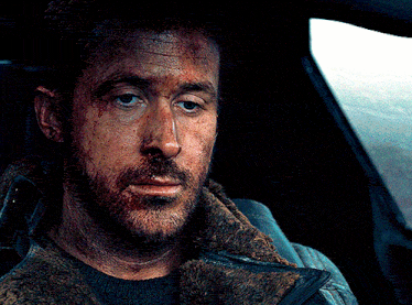 a man with a beard is sitting in a car and looking out the window