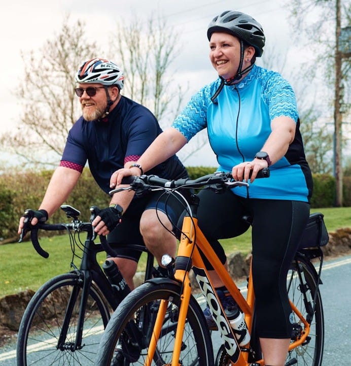 a man and a woman riding bikes on a road