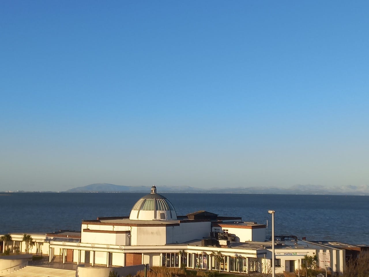 Fleetwood's Marine Hall with the Cumbrian hills in the distance across Morecambe Bay
