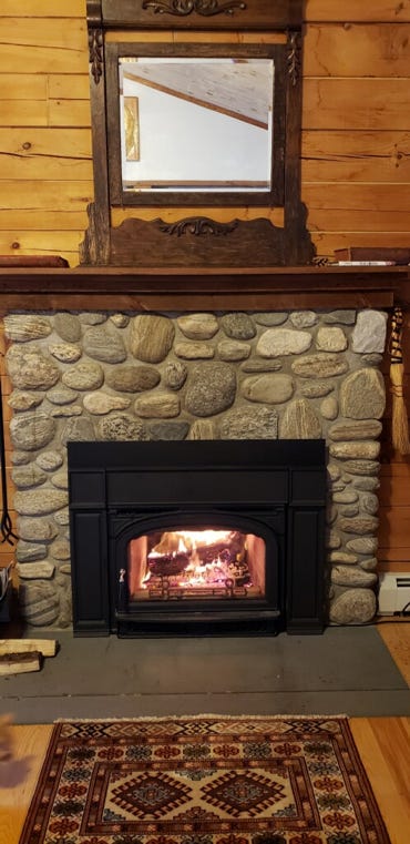 A fireplace with a wood shelf above it

Description automatically generated