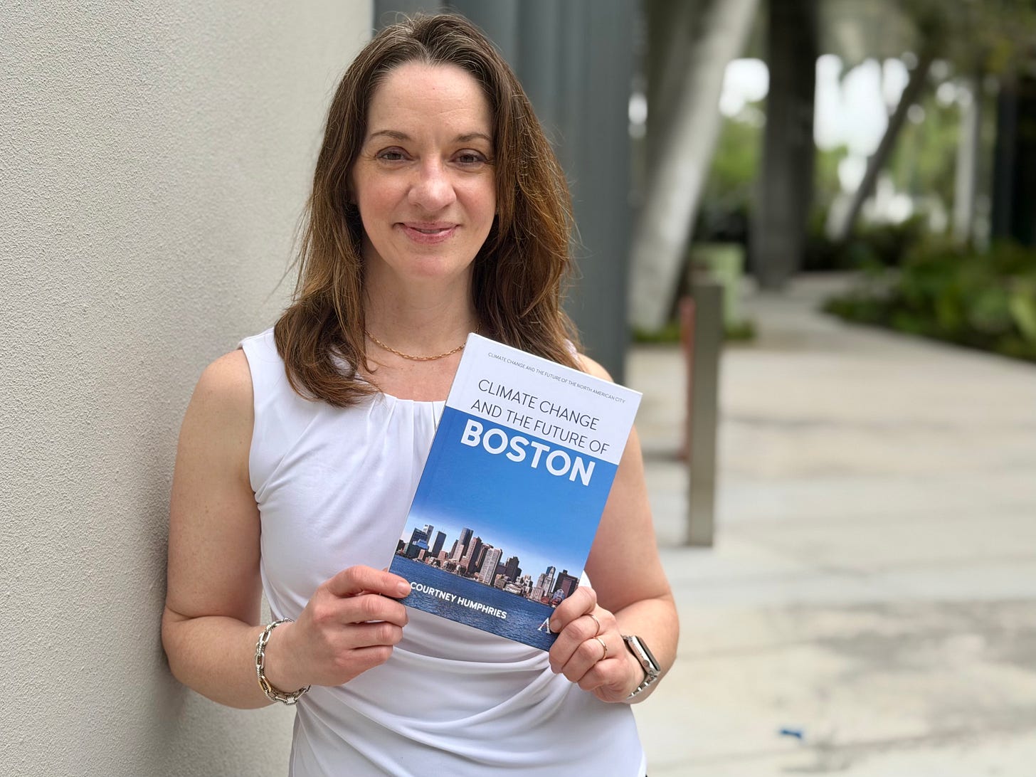 Courtney Humphries standing in Miami holding a copy of her book. Courtney Humphries standing in Miami holding a copy of her book.