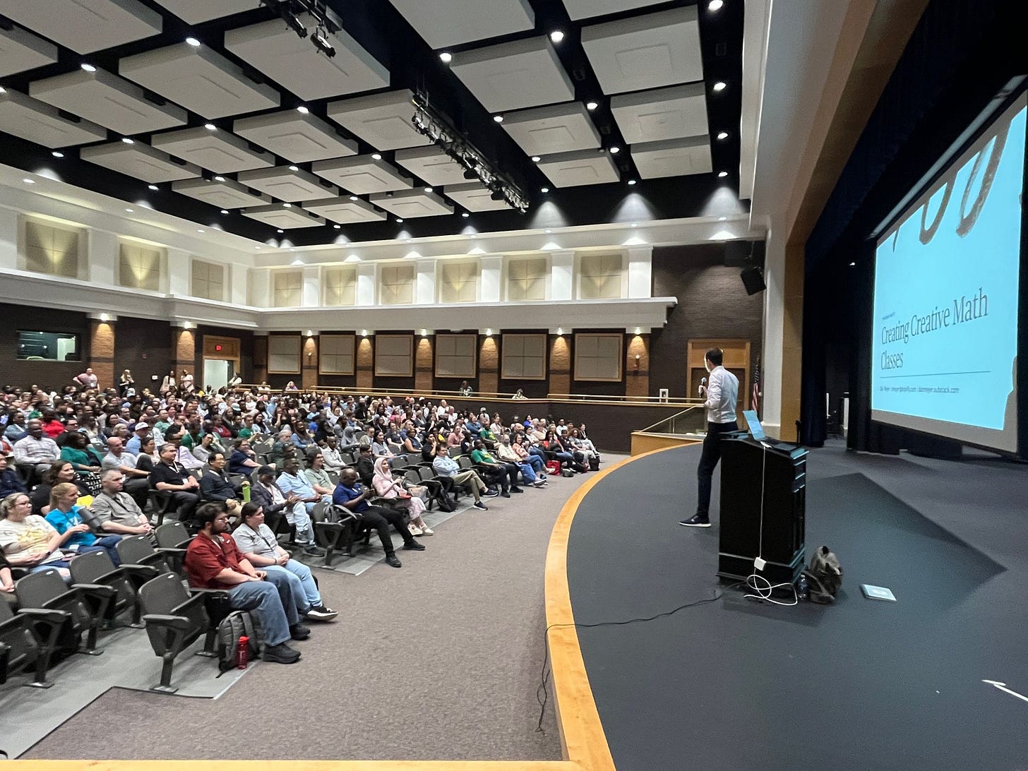 An image of yours truly giving a presentation in an auditorium.