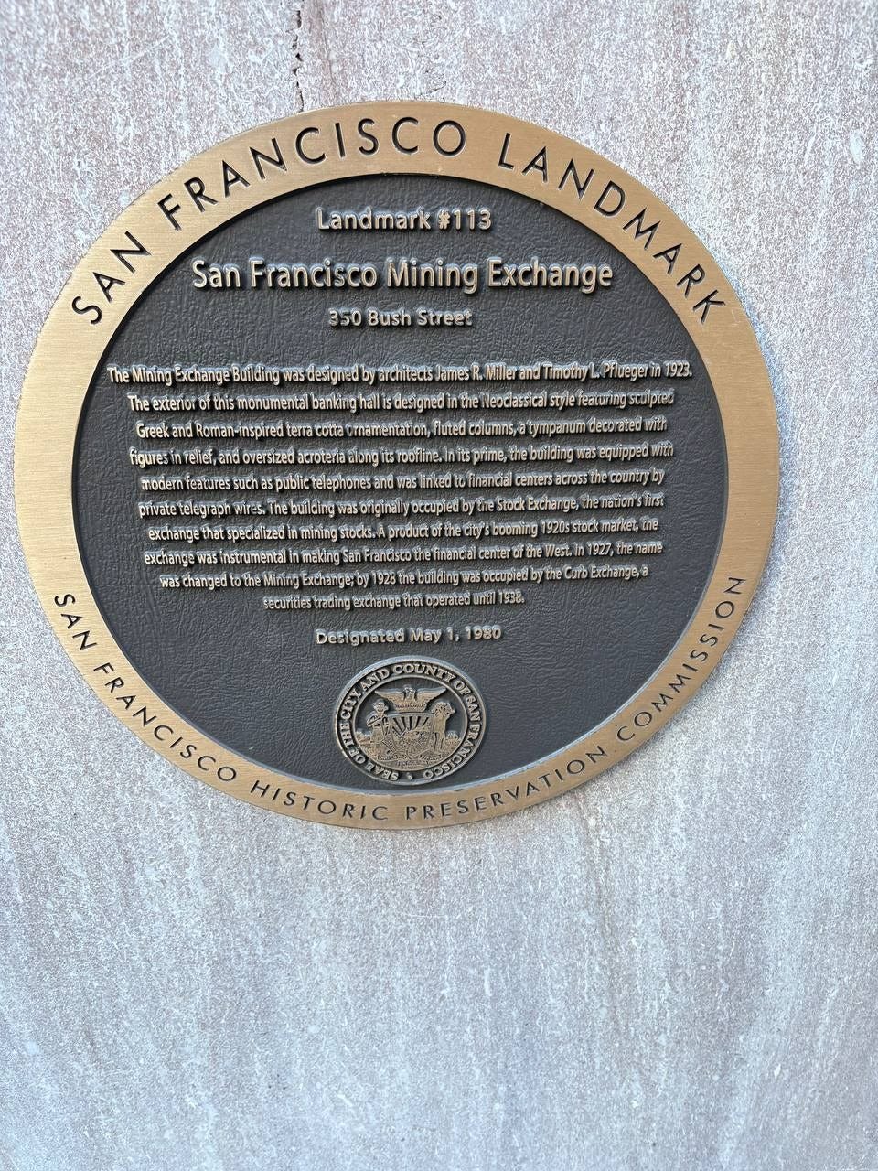 May be an image of monument and text that says 'FRANCISCO SAN San Francisco Mining Landmark #113 Exchange LANDMARK LANDNAT 350 Bush Street The TheMining Exchange Butlding designed architec Pllueyer 1923 The exterior this thismonumenta banking halli designed กา leoclassical styie featuring Greeka Roman-inispired terra coйa mamentation. fluted columins, tympanum decorated เ้ขึก Telief, พอลี่ยก features pivatetelegrapn exchangethats specialized that roofline. linked centers across พลร changed 920sstockmarket,E thename name Curb Exchange/a Designated May 1980 N SAN SAN FRANCISCO HISTORIC VIS COUNTY CLTY FBAT PRESERVATION ΙΥΑΟΝ'