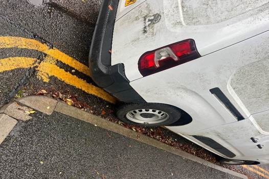 A white car with a tire on the side of the road

AI-generated content may be incorrect.