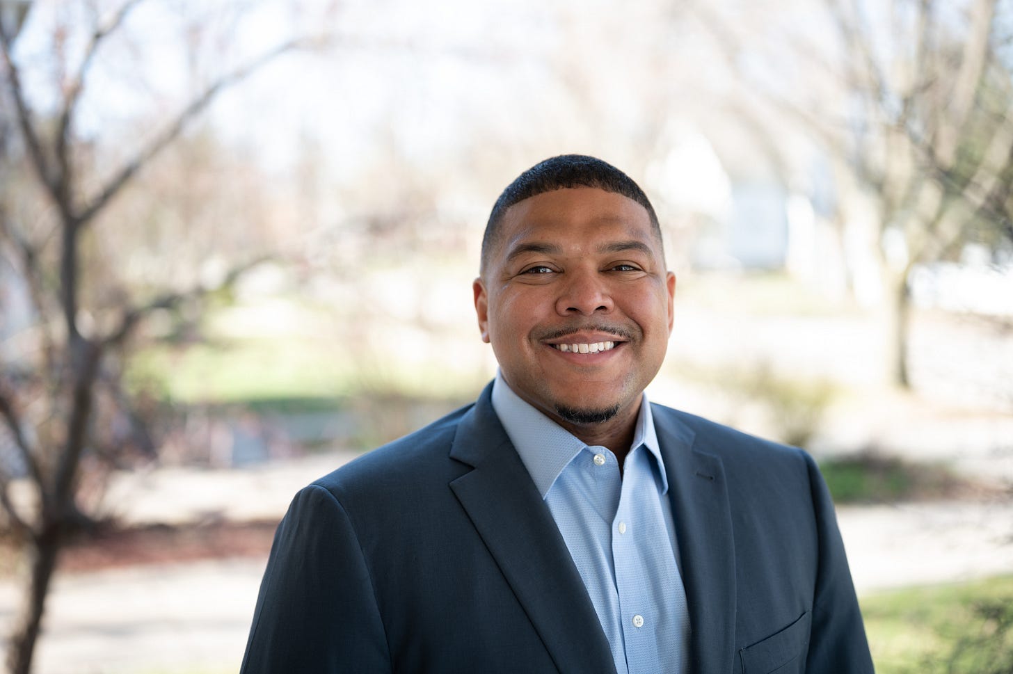 Wisconsin State Rep. Amaad Rivera-Wagner smiles for the camera, dressed in a suit and tie.