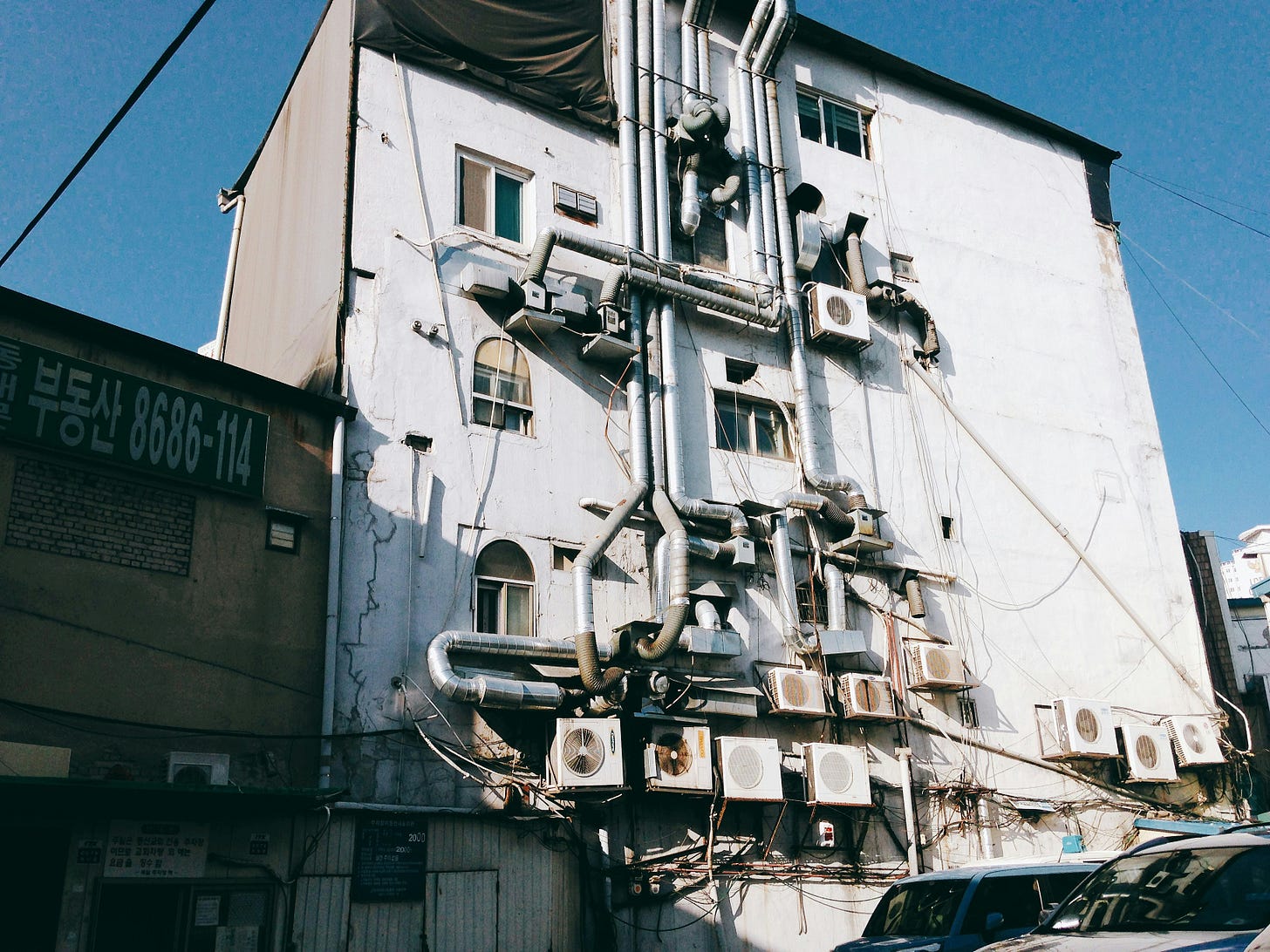 A building with complex ductwork and air conditioning systems on the back
