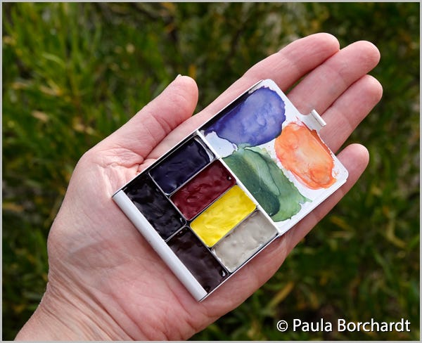 My hand holding my new teeny tiny watercolor palette