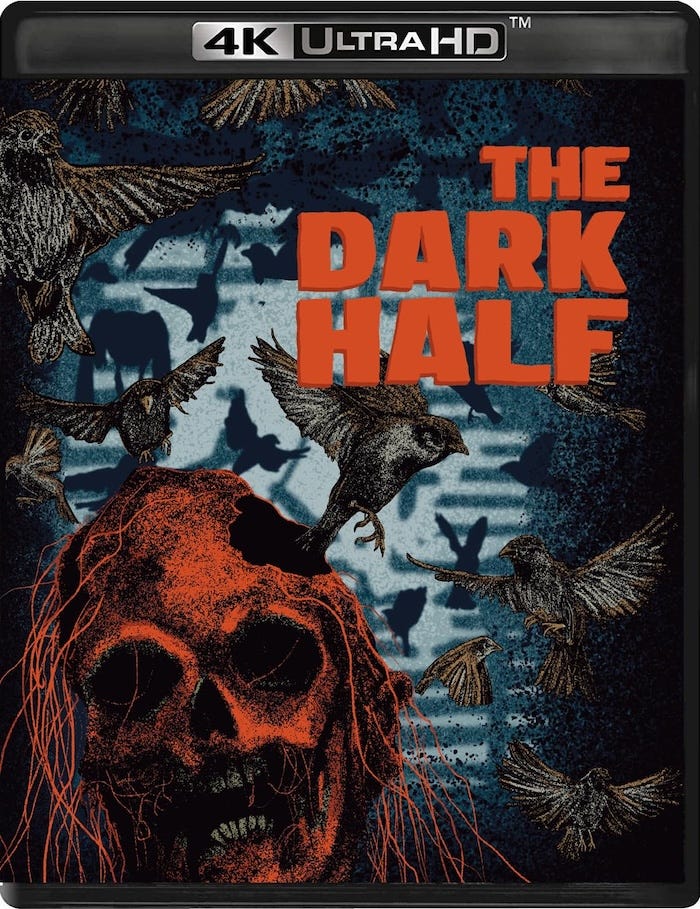 Illustrated cover artwork for Vinegar Syndrome’s 4K UHD release of The Dark Half featuring a decaying skull with red hair, surrounded by blackbirds in flight. The title appears in bold red block letters against a textured blue background. Illustrated cover artwork for Vinegar Syndrome’s 4K UHD release of The Dark Half featuring a decaying skull with red hair, surrounded by blackbirds in flight. The title appears in bold red block letters against a textured blue background.
