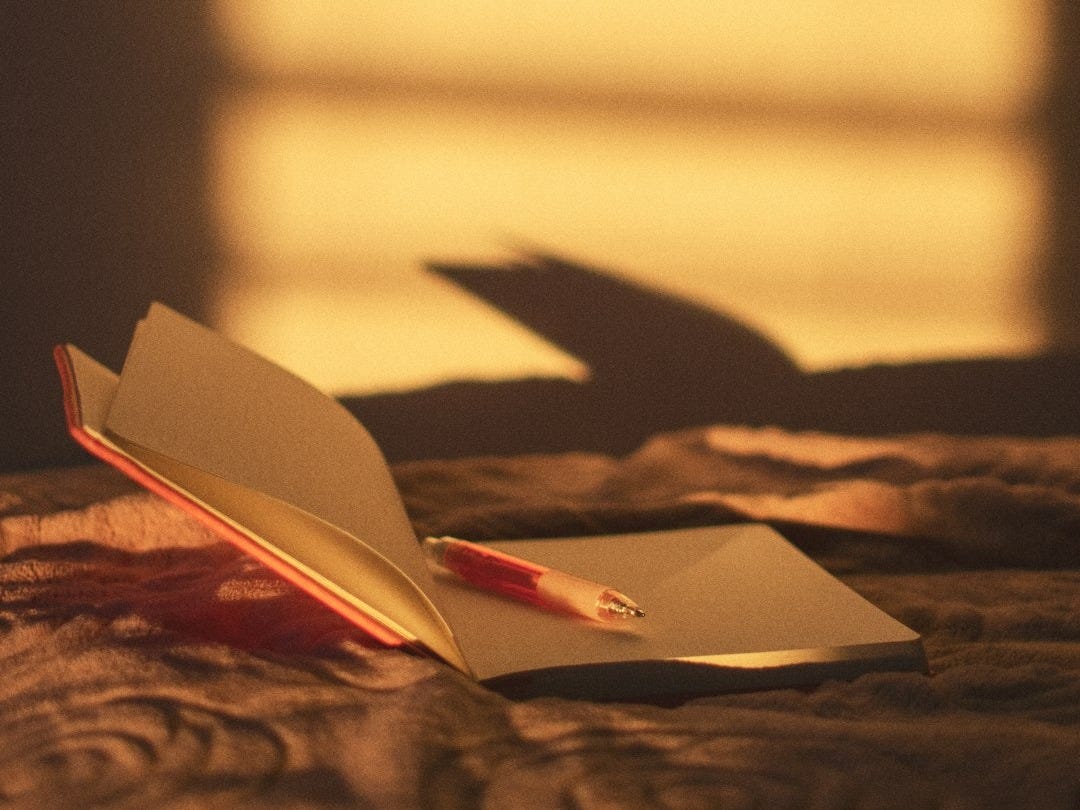 orange click pen on opened book