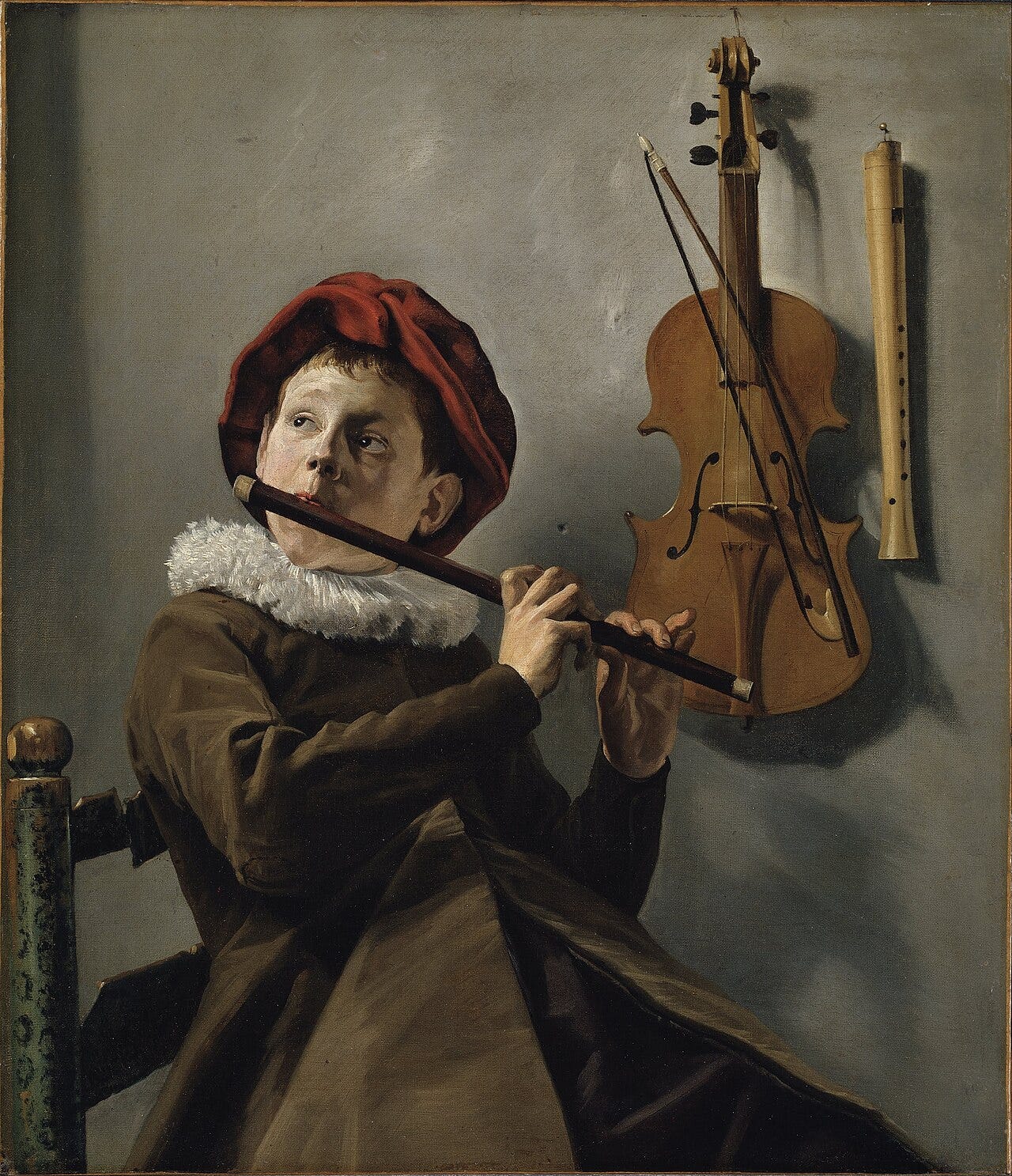 A boy in a cap leaning back and playing a recorder A boy in a cap leaning back and playing a recorder