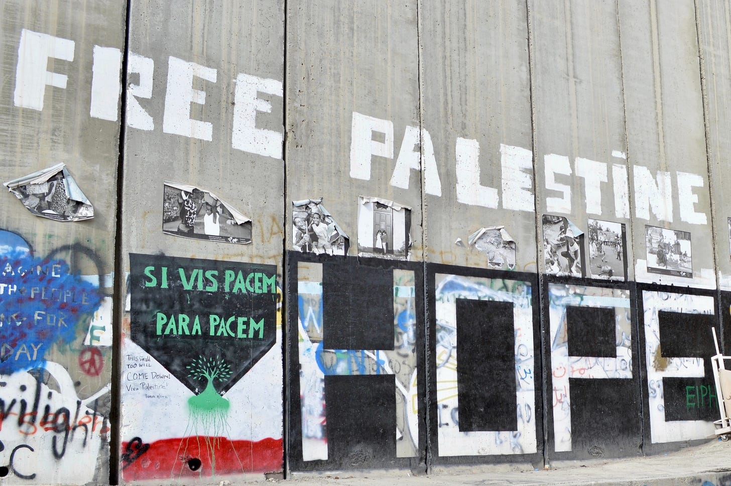 A concrete separation wall between Gaza and Israel that is full of graffiti that reads Free Palestine and Hope