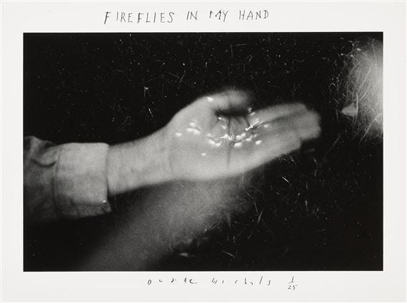This may contain: a black and white photo of a person's hand holding something in the air