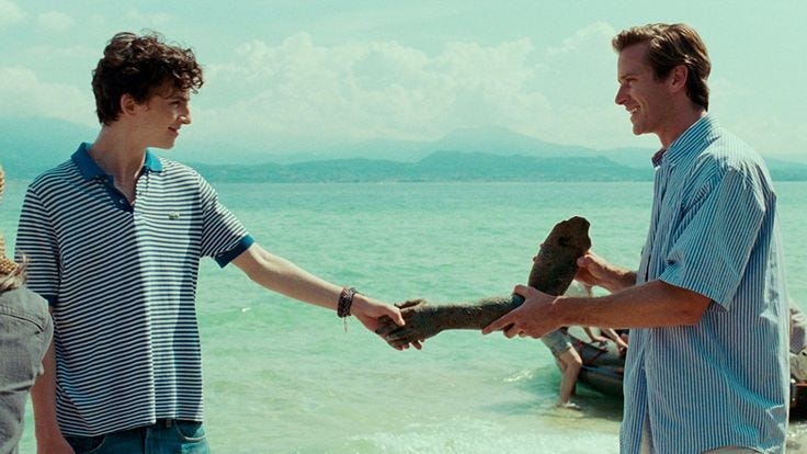 This may contain: two men are shaking hands on the beach