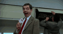 a man in a suit and tie is holding a ticket for a plane a man in a suit and tie is holding a ticket for a plane