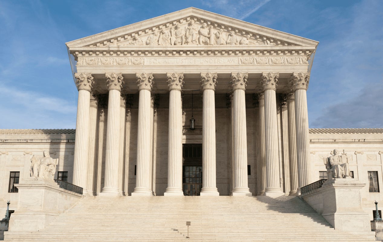 United States Supreme Court Building with columns and a blue sky

Description automatically generated