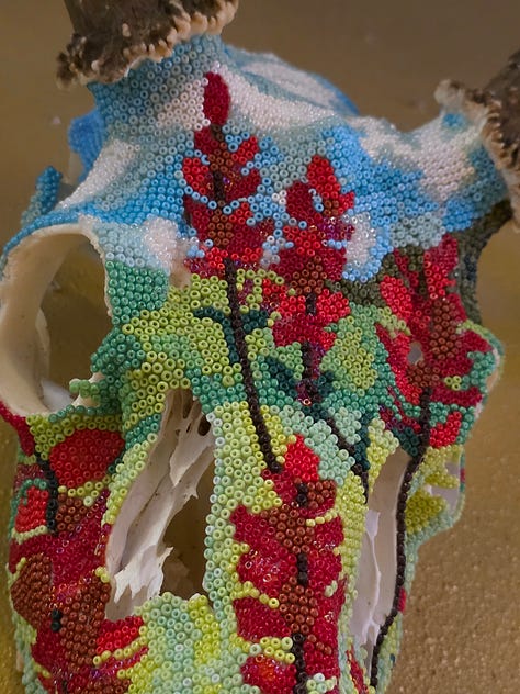 Three images. 1. A deer skull with thousands of small beads glued to it, creating an illustration of green hills, blue sky with white clouds, and numerous red wildflowers known as paintbrush. 2. A trompe l'oeil mural of a yellow post-it note with a jackalope (jackrabbit with antelope horns) and text that reads "Our greatest fear should not be failure, but of succeeding at something that doesn't really matter." 3. Child's sketches of a bird, a dandelion, and other nature observations.