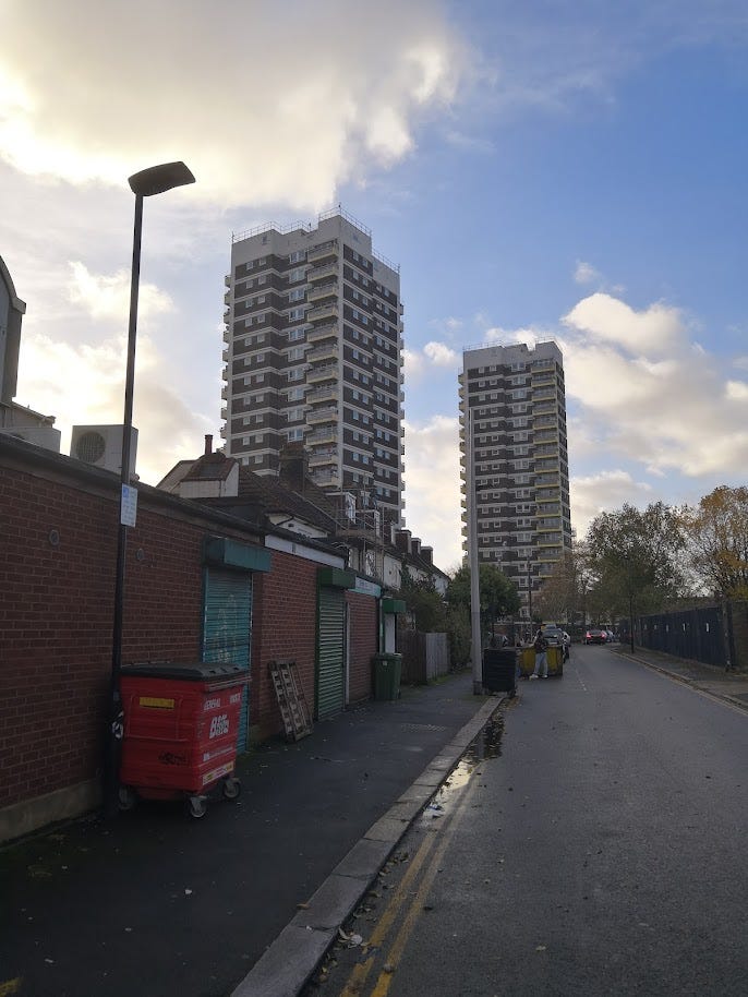 Two tower blocks under sunshine and clouds