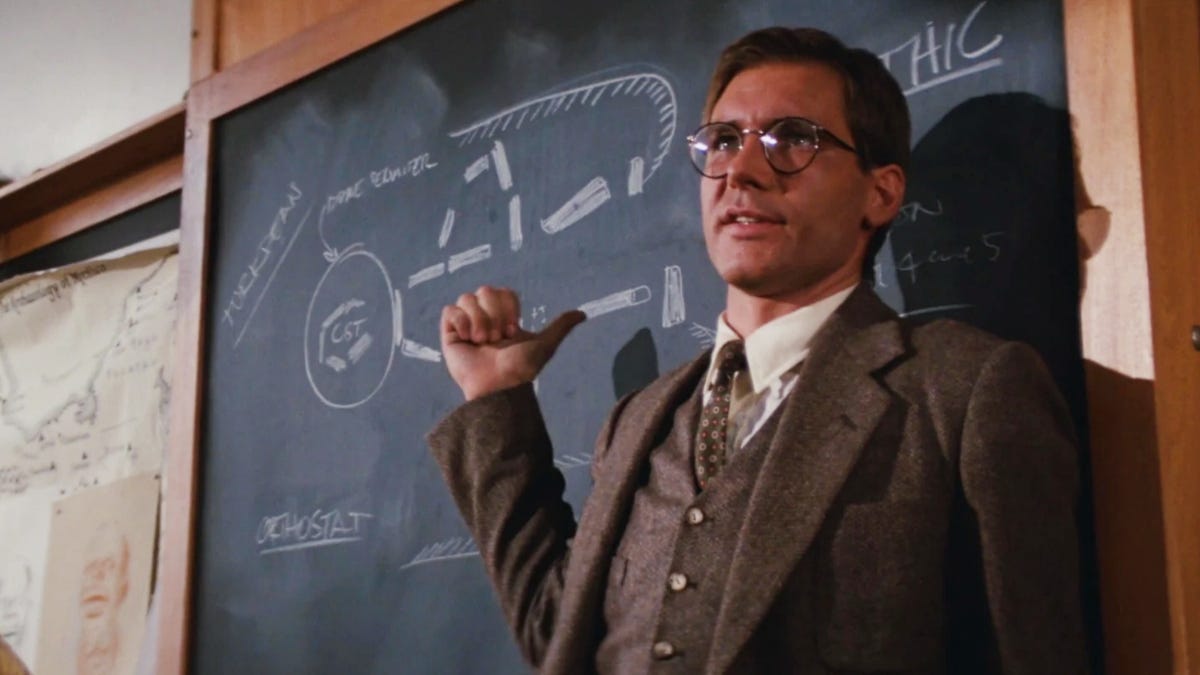 image of Indiana jones in front of a chalkboard teaching