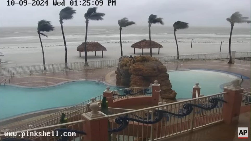 Video screenshot showing a deserted Florida beach with heavy surf and palm trees being blown in the wind Video screenshot showing a deserted Florida beach with heavy surf and palm trees being blown in the wind