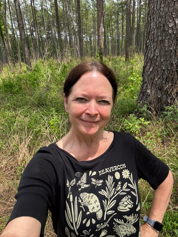 Congaree National Park entrance sign and me in a field of longleaf and loblolly pine