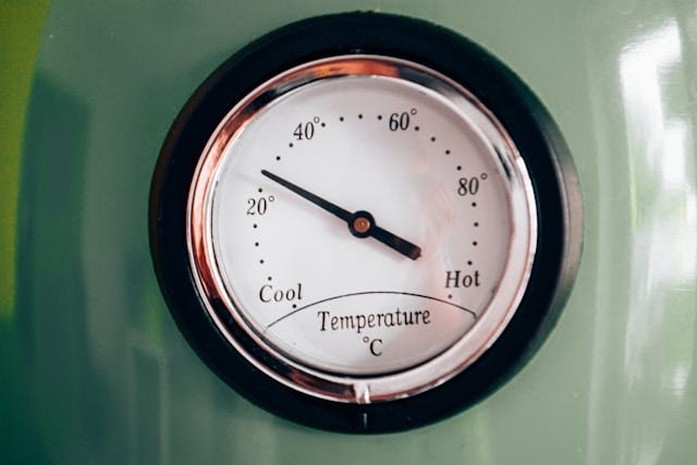 Image of a spherical temperature gauge with the needle a third of the way. between 'cool' and 'hot'. 