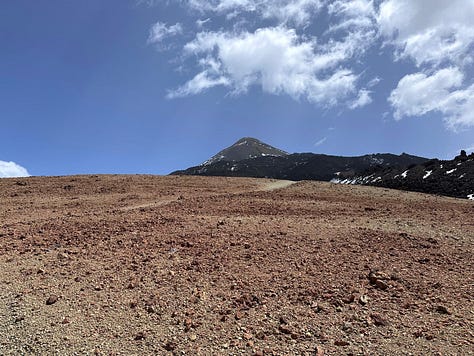 The raw volcanic terrain of Montana Blanca, rocky hills rising on both sides of the empty hiking path.
