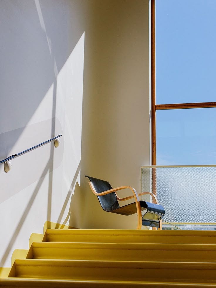 This may contain: a chair sitting on top of yellow steps next to a window